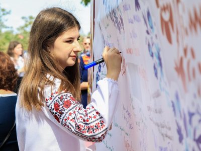 Випускниця пише на плакаті