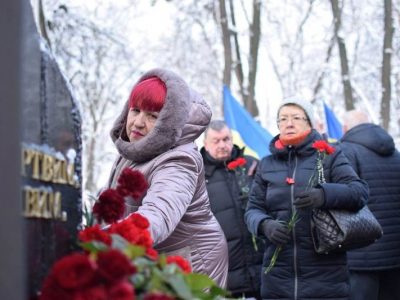 Люди кладуть квіти до пам'ятника