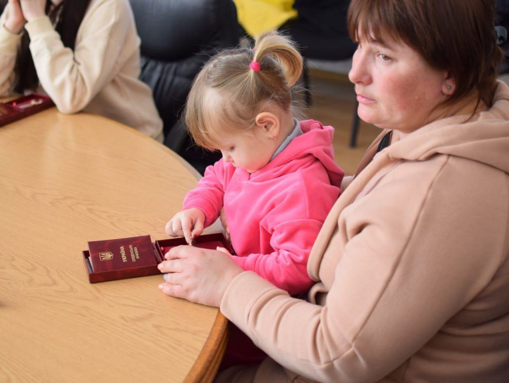 Дівчинка з мамою отримують нагороду полеглого захисника