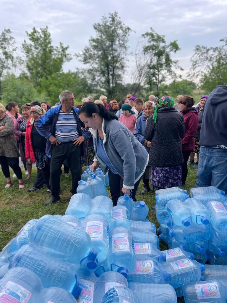 Жінка бере пляшки з водою