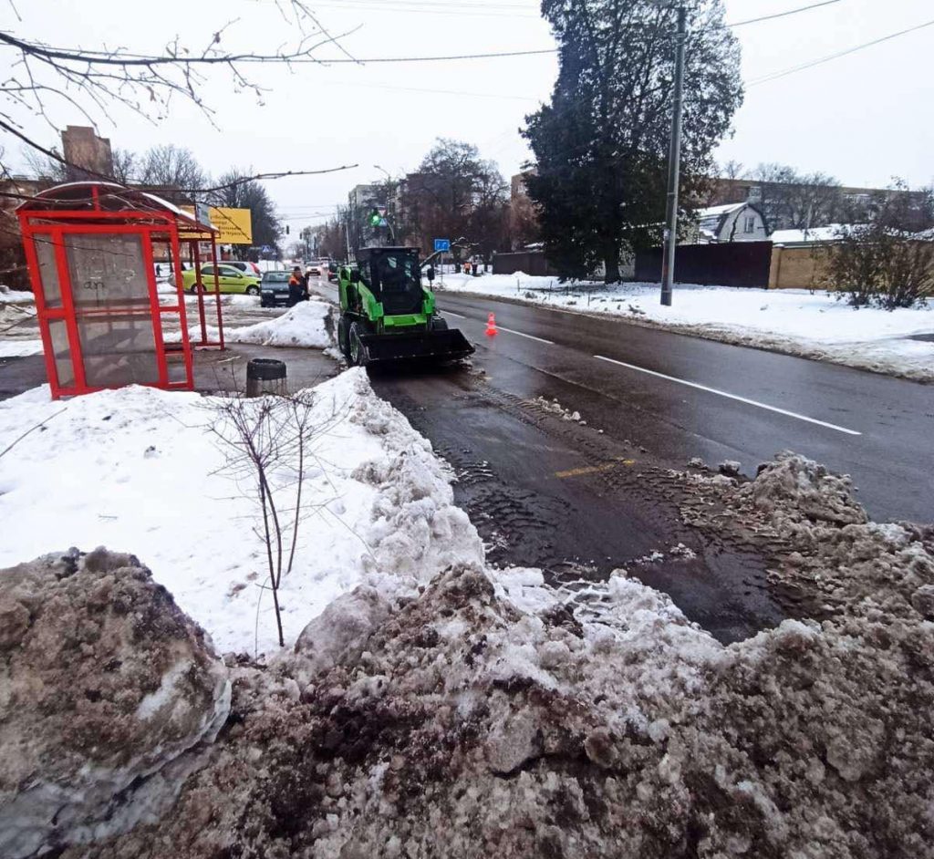Трактор очищує зупинки від снігу