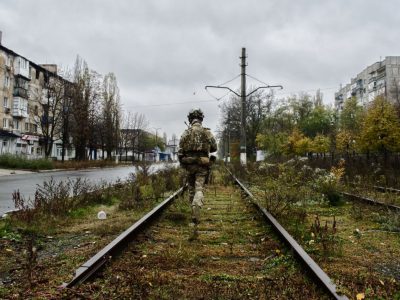 Військовий йде по рельсах