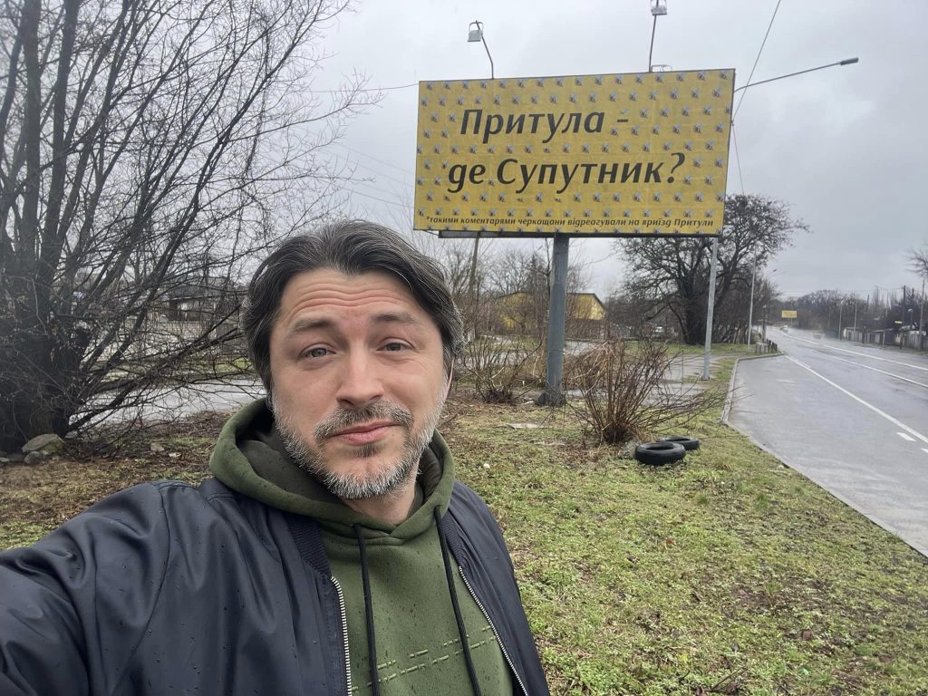 Сергій Притула на фоні білборду в Черкасах