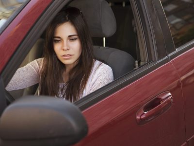 Жінка в червоному автомобілі