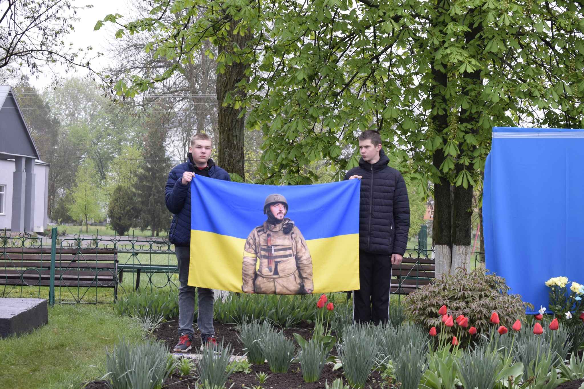 хлопці тримають прапор України, на якому зображений Михайло Волощенко