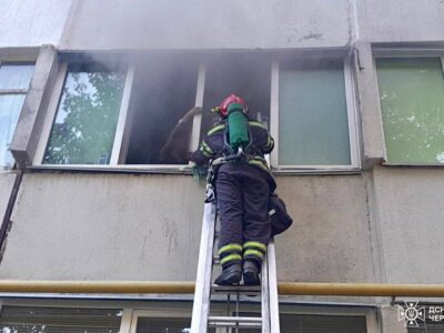 працівник ДСНС рятує потерпілих унаслідок пожежі в Смілі