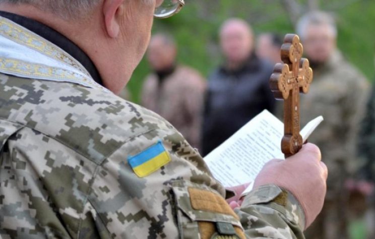 капелан на службі читає книгу