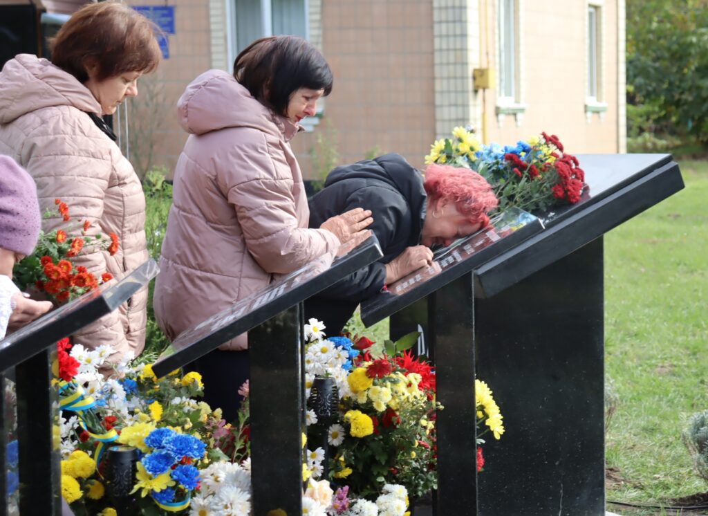 жінка плаче біля Алеї пам'яті захисників у Сатанівці