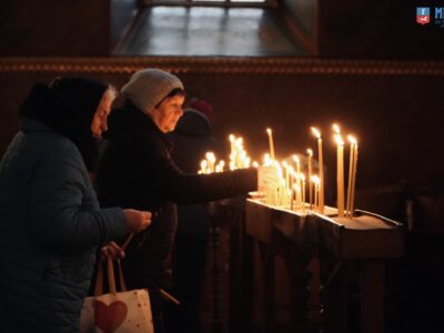 жінки ставлять свічки у храмі