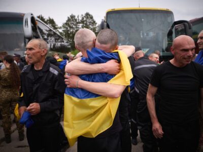 визволені військовополонені обіймаються після повернення в Україну