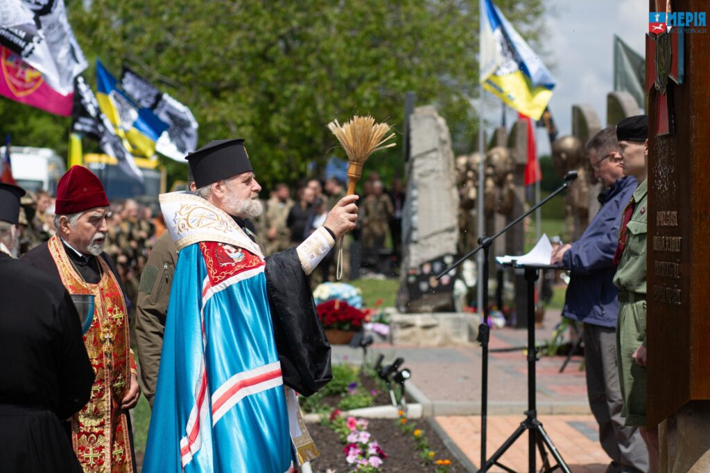 священник освячує пам'ятники у Холодному Ярі