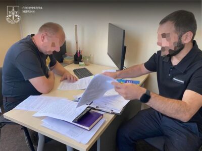 чоловік підписує лист паперу