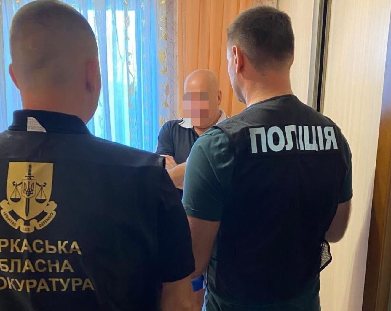 двоє правоохоронців вручають підозру