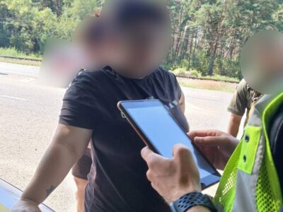 чоловік біля авто поліції