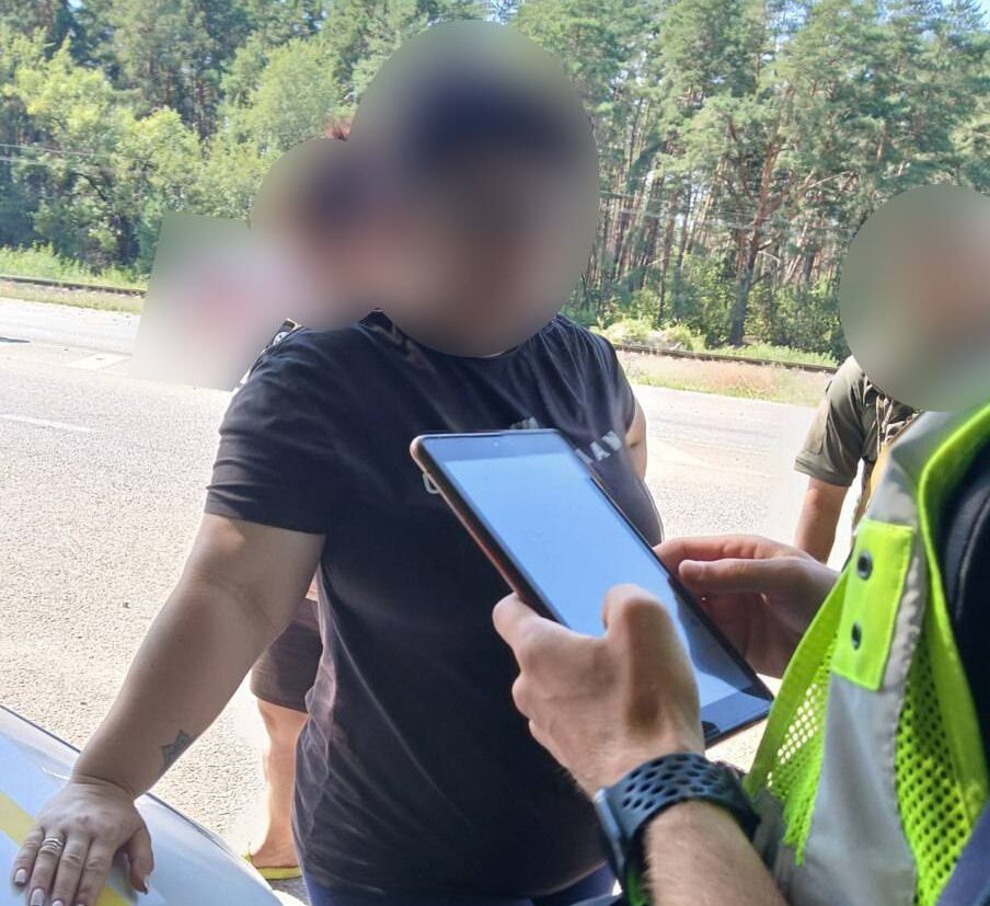 чоловік біля авто поліції