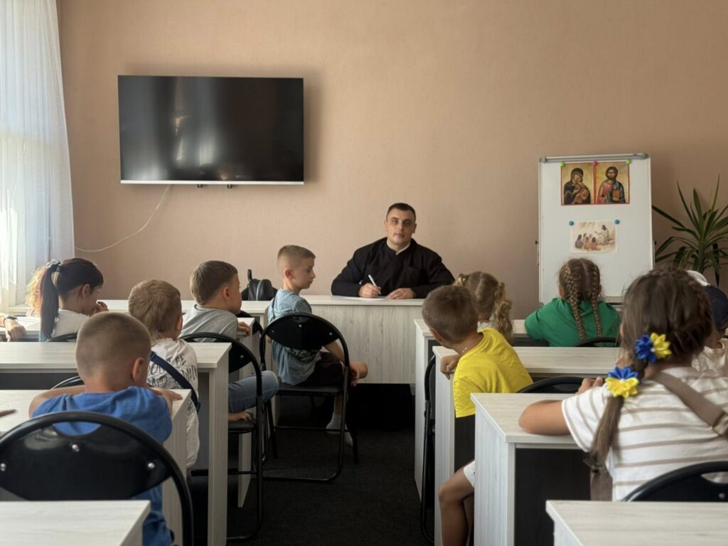 священник викладає дітям у недільній школі при соборі