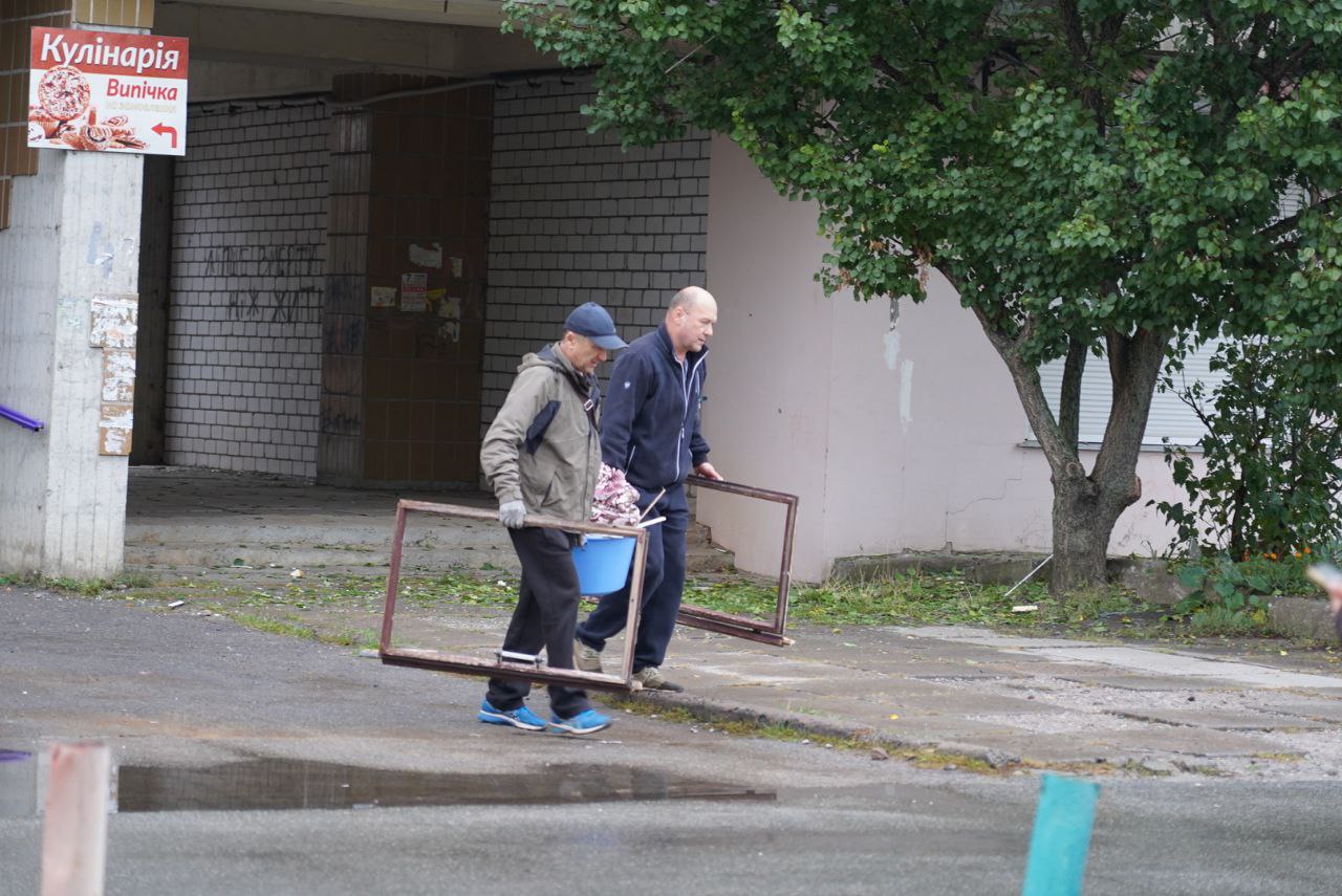 Чоловіки несуть вікна 