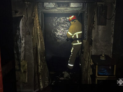 пожежник гасить вогонь у будинку на Звенигородщині