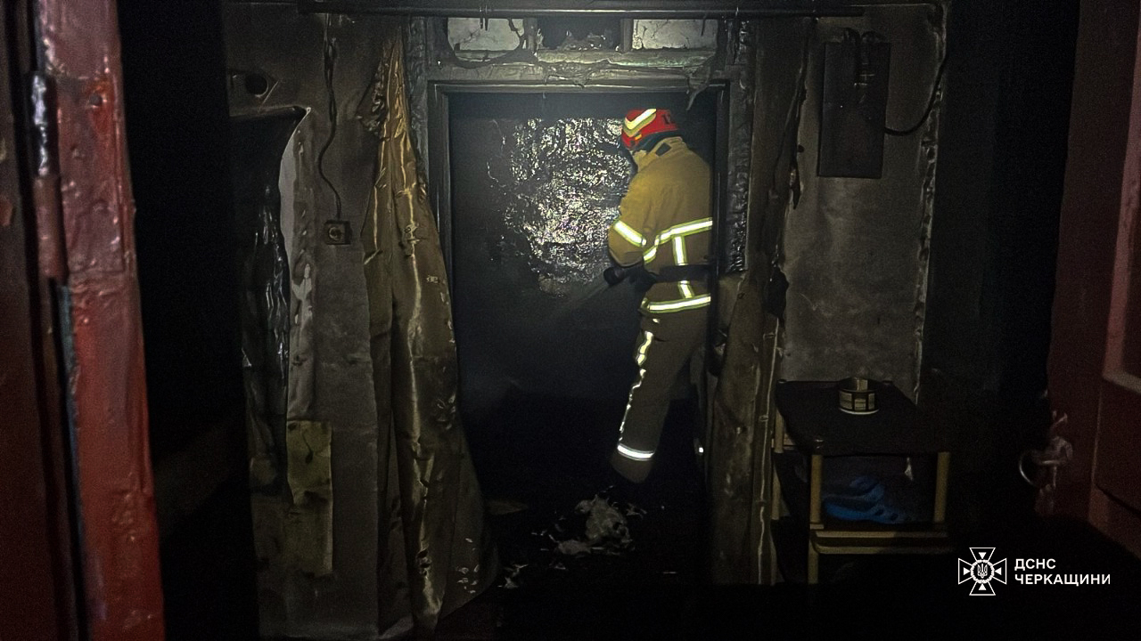 пожежник гасить вогонь у будинку на Звенигородщині