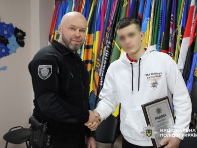 поліцейський тисне руку школяру