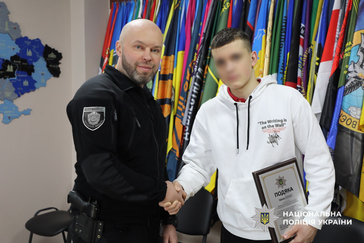 поліцейський тисне руку школяру