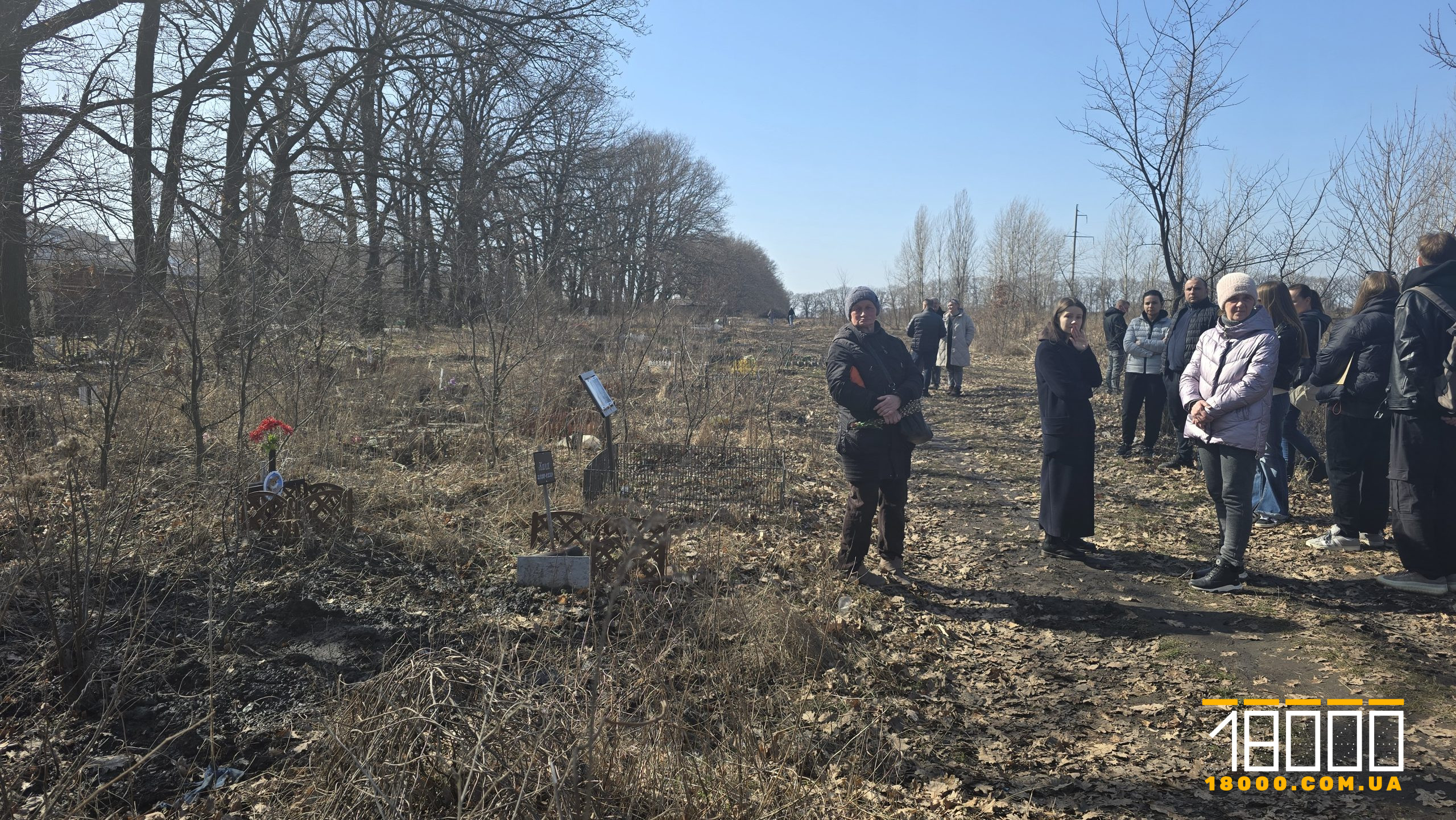 Люди на полі, де облаштували кладовище