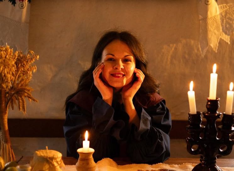 жінка за столм зі свічками