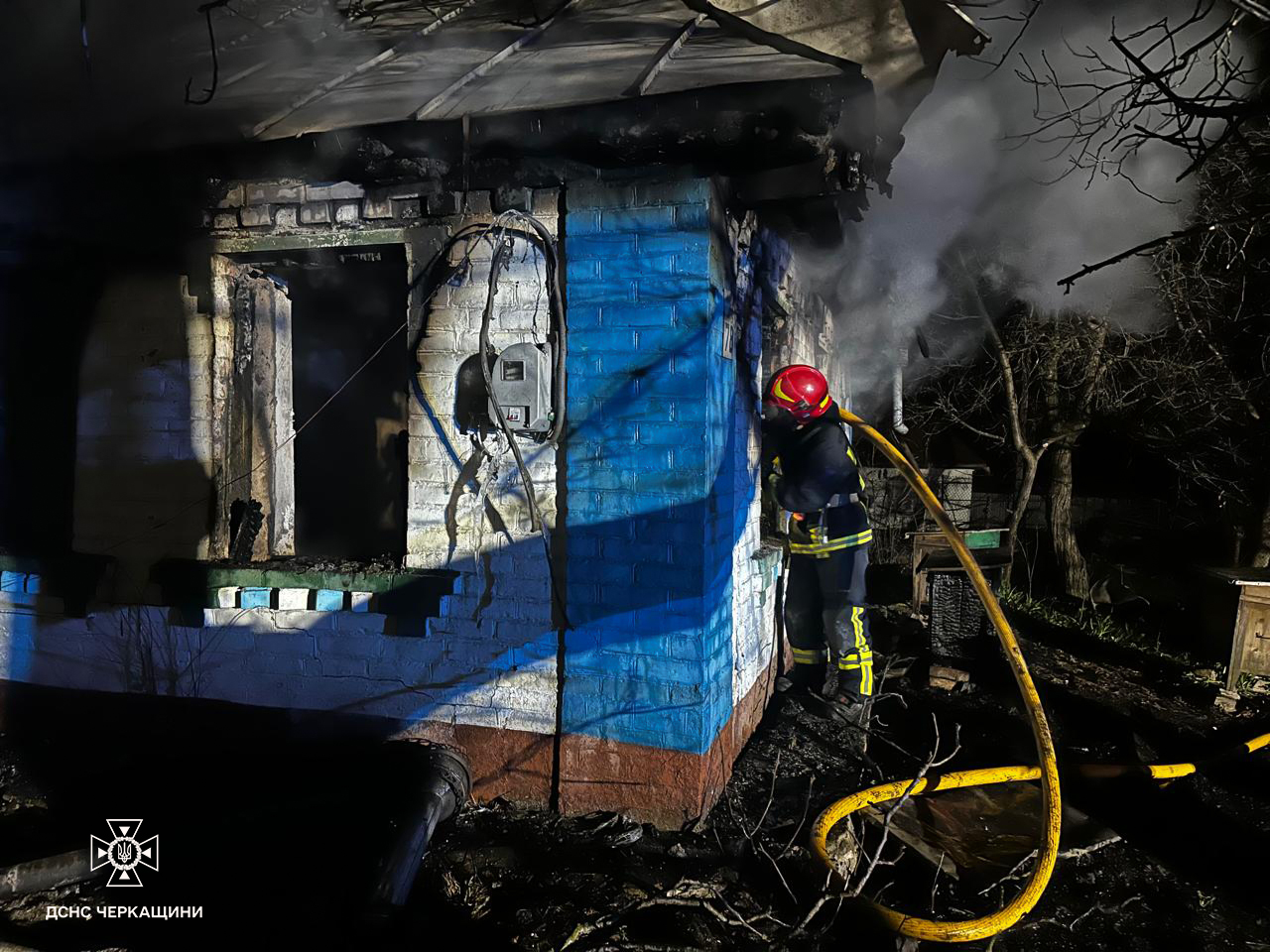 пожежник гасить будинок