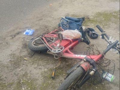 червоний велосипед на узбіччі дороги