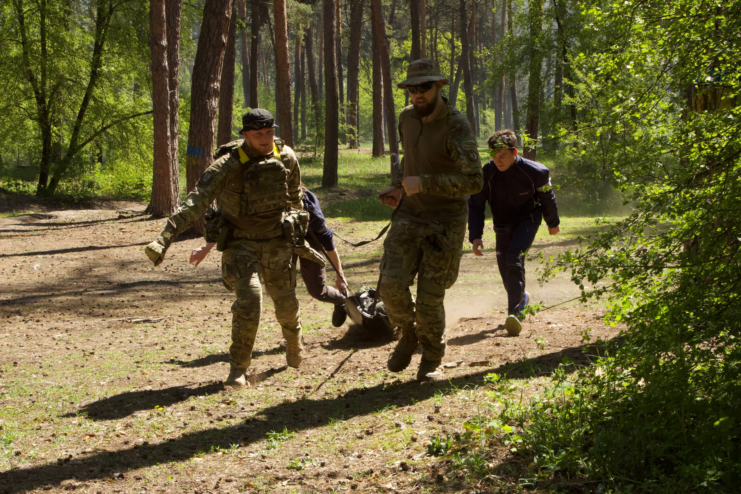 Люди у формі несуть іншу людину