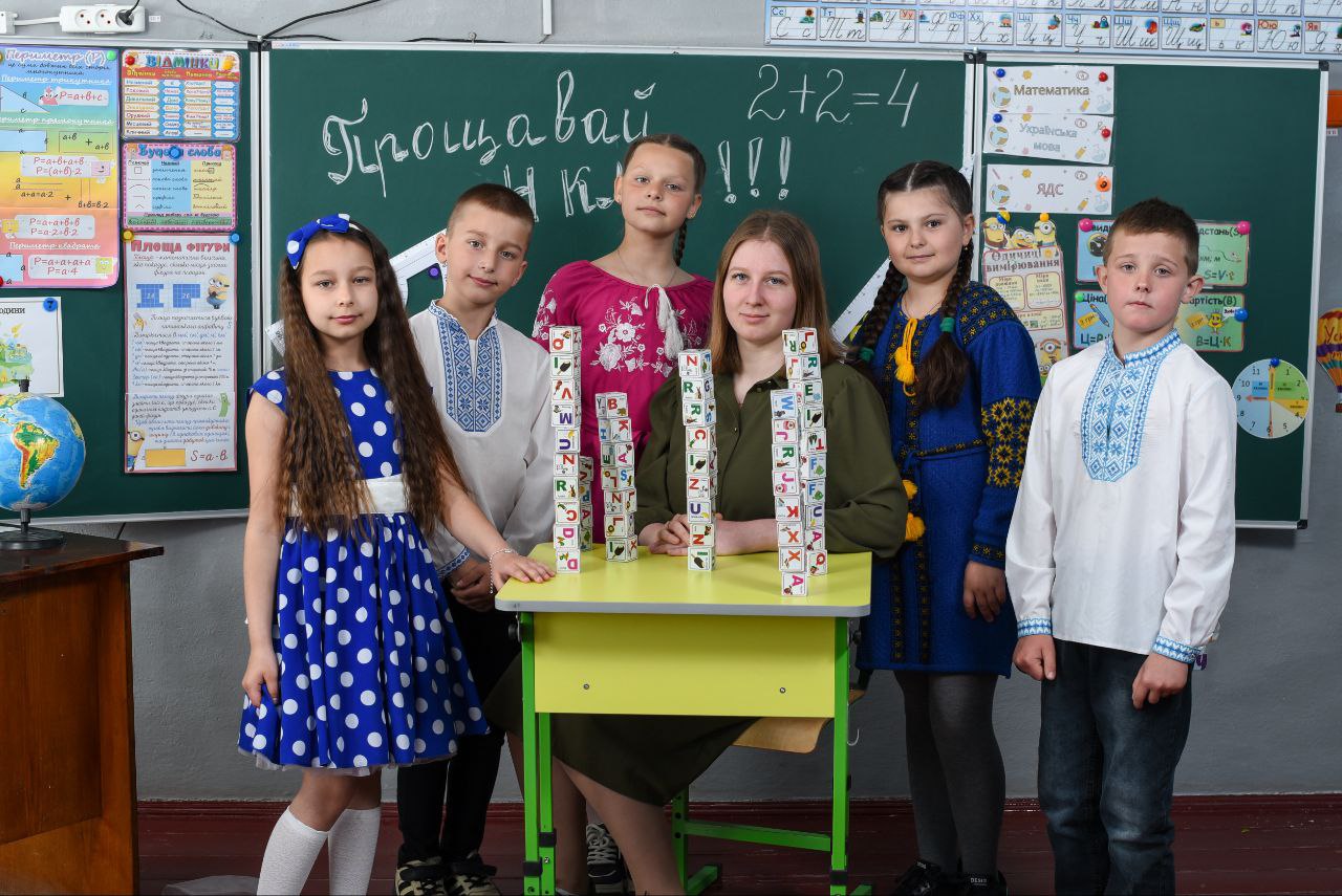 діти і вчителька за партою