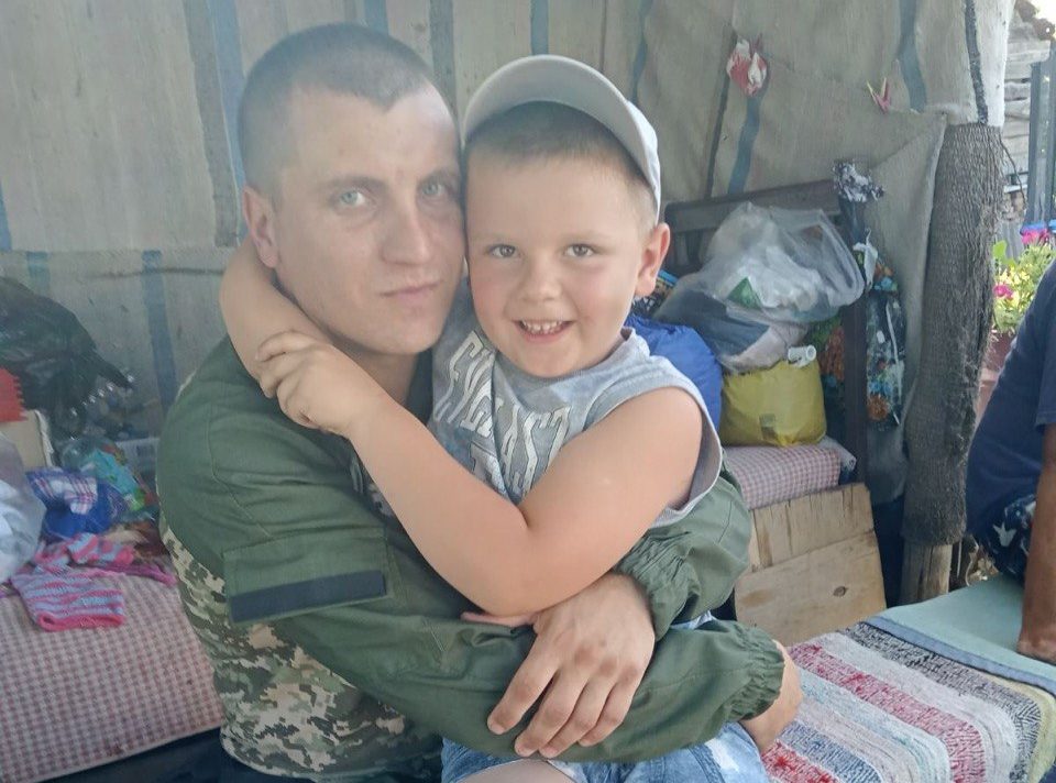 Чоловік у військовій формі із дитиною на руках