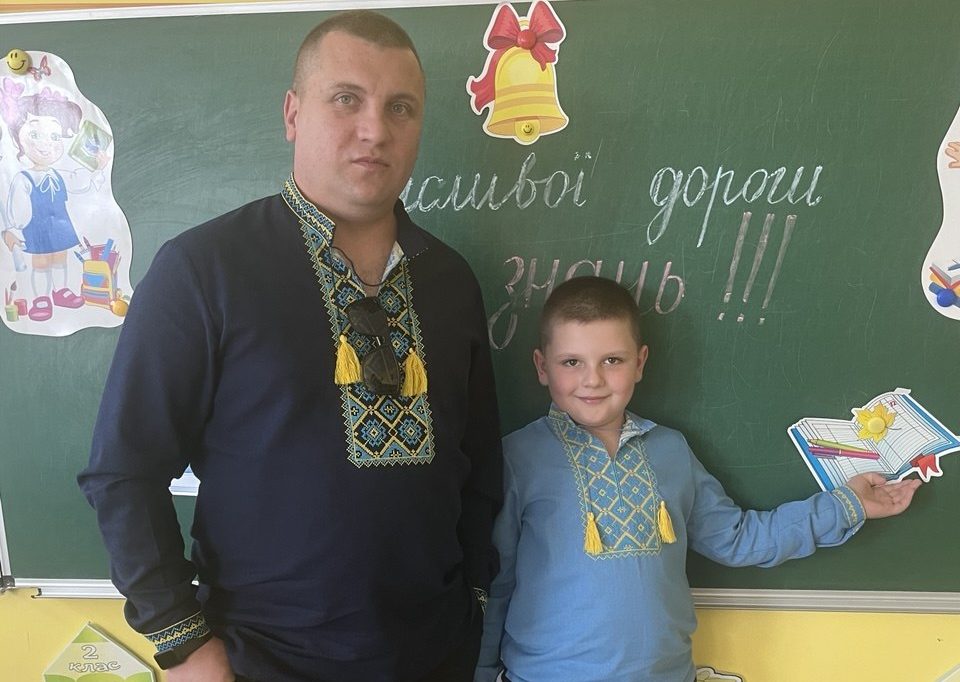 Чоловік і хлопчик у вишиванках біля дошки