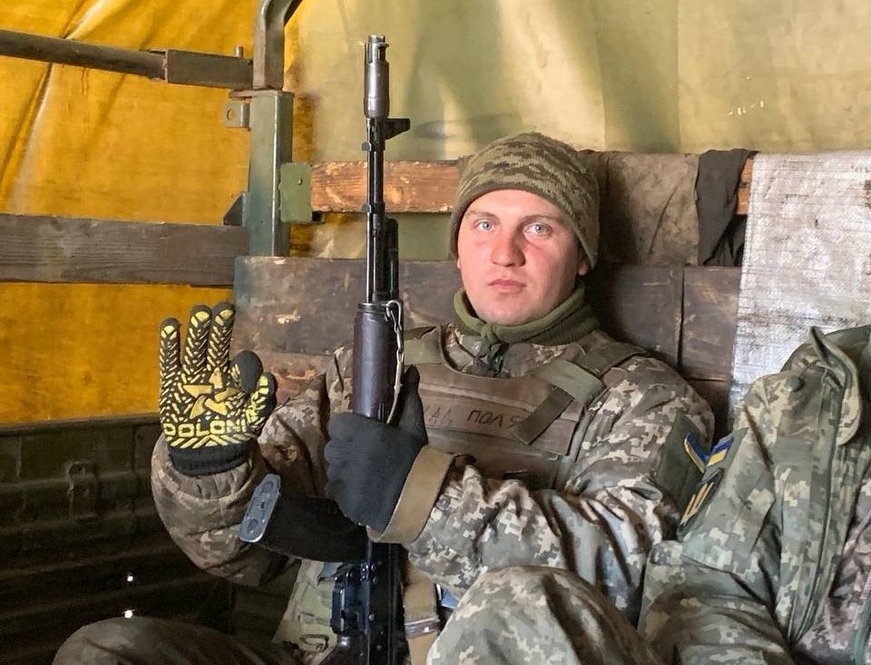 Чоловік у військовій формі тримає автомат
