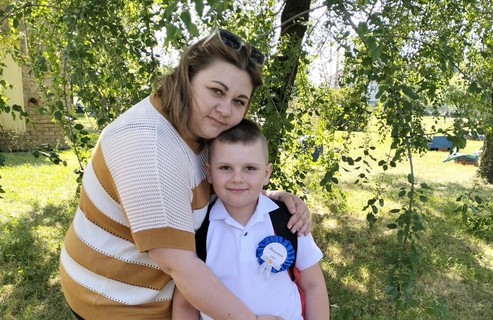Жінка із маленьким хлопчиком на фрні дерев