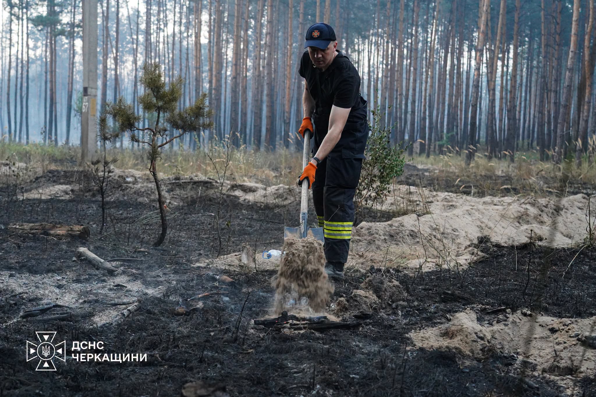 Рятувальник сипле пісок на дрова