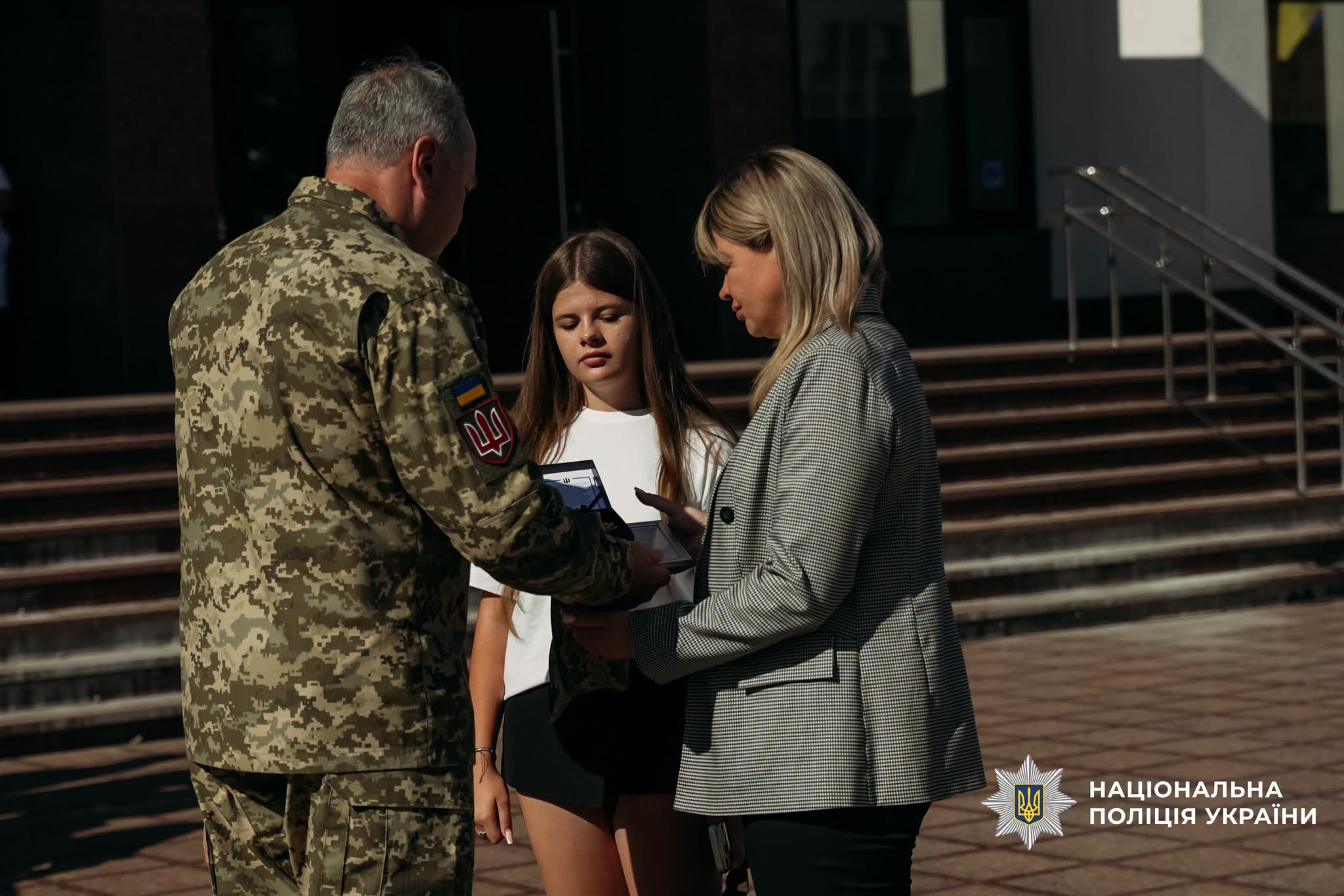 Жінка з дитиною отримує нагороду
