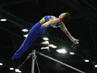 Спортивний гімнаст Назар Чепурний у польоті над брусами
